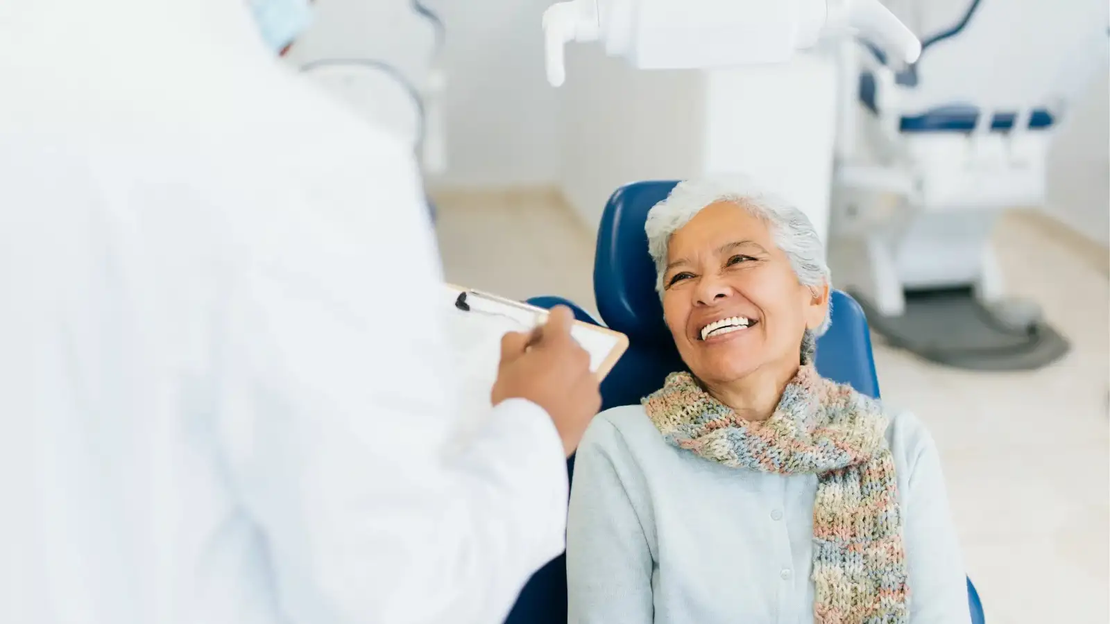 Elderly woman in exam chair with denturist